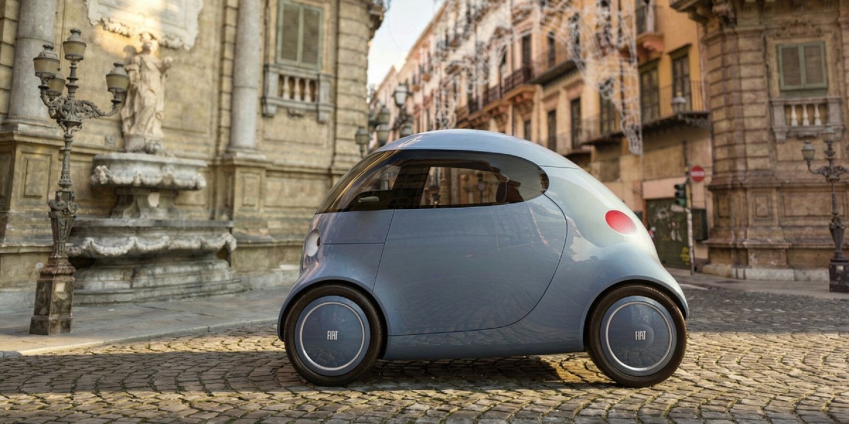 Compact blue Fiat Topolino XS parked on cobblestone in front of ornate building