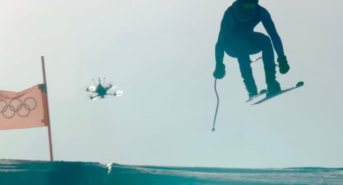 Skier performing jump mid-air with Olympic flag Milan Cortina 2026